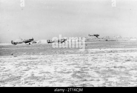 Royal Air Force- Operations in Malta, Gibraltar and the Mediterranean, 1940-1945. A section of three Supermarine Spitfire Mark VC(T)s of No. 249 Squadron RAF waits at readiness by the main runway at Ta Kali, Malta, as a Bristol Beaufighter comes in to land. Stock Photo
