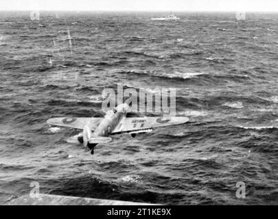 A Hawker Sea Hurricane of 825 Squadron, Fleet Air Arm takes off from the flight deck of HMS Vindex during an Atlantic convoy. One of the carrier's escort vessels can be seen ahead. Stock Photo