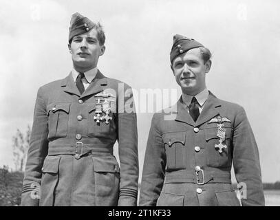 Flight Lieutenant R H A Lee and Flying Officer K H Blair, after being decorated by King George VI at RAF Hornchurch, Essex, 27 June 1940. Flight-Lieutenant R H A Lee, after being awarded the DSO and DFC, and Flying Officer K H Blair, after being awarded the DFC, by King George VI at RAF Hornchurch, Essex. The awards were given for their distinguished service as fighter pilots with No. 85 Squadron RAF in France. Lee, a flight commander with the Squadron, was posted missing in action on 18 August 1940, having destroyed at least 9 enemy aircraft. Blair flew with No. 151 Squadron RAF during the Ba Stock Photo