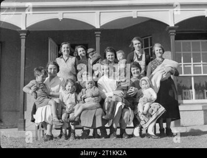 Evacuees To a Communal Hostel in Thurlestone, South Devon, England, 1941 A group of women and children evacuated from their homes in Bristol pose for a photo with Matron outside the Swallows Communal Billet in Thurlestone, South Devon. Mrs Winter (wearing white overalls in the centre of the photograph) is originally from Hampton in Middlesex and is in charge of five Ministry of Health Communal Billets in South Devon. Stock Photo