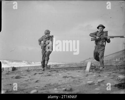 Luxembourg Troops Fight With United Nations- Training With the Belgian Army in England, UK, 1943 Two soldiers from Luxembourg run along the sand during a bayonet charge as part of a training session with the Belgian Army along the coast, somewhere in England. Stock Photo