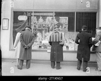 Ministry of Information Exhibitions during the Second World War, London, England, UK, 1943 Men and women crowd around a window display at Selfridge's in London. The display is part of an exhibition about the campaign in East Africa, entitled 'How Italy lost her Empire'. The pictured window is entitled 'Chapter 1. Abyssinia - first to be freed'. Stock Photo