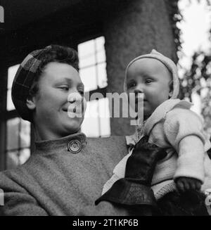 Nursery For Working Mothers- the work of Flint Green Road Nursery, Birmingham, 1942 8 month old Keith arrives at the nursery for the day at 7am. His mother gives him a hug goodbye before she leaves for a day's work. Stock Photo
