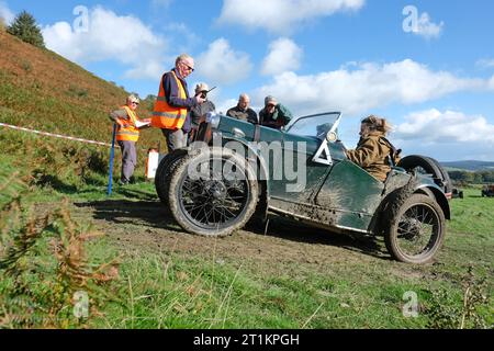 Badlands Farm, Kinnerton, Powys, Wales, UK – Saturday 14th October 2023 – Competitors in an Austin 7 ( built 1930 ) wait with marshalls at the start line of the difficult off road course of the Vintage Sports Car Club ( VSCC ) Welsh Trials in glorious autumn sunshine in Mid Wales. Photo Steven May / Alamy Live News Stock Photo