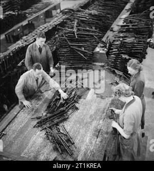 Sten Gun Production in Britain, 1943 Workers assemble Sten guns at Royal Ordnance Factory Fazakerley, near Liverpool. It is essential that each part fits perfectly and is not too loose or tight. If parts do not fit easily, they will be rejected as, according to the original caption, 'A man's life, or the life of a platoon or a company may depend on good workmanship'. Stock Photo