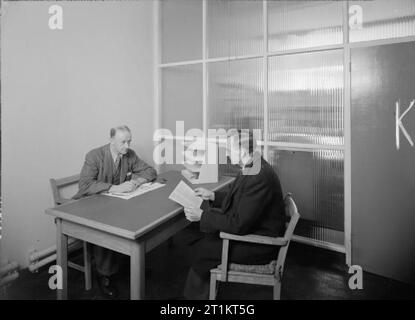 The Resettlement Advice Service of the Ministry of Labour and National Service Member of staff providing advice to an enquirer in one of the interview rooms of the Resettlement Advice Service office in Bishops Stortford. Stock Photo