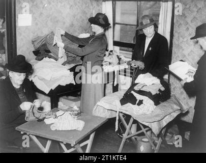 The work of the Citizens' Advice Bureau, Eldon House, Croydon, England, 1940 Clothes are sorted by female volunteers of the Personal Service League at the Citizens' Advice Bureau in Croydon. These clothes would be distributed to those in need in the local area. Stock Photo