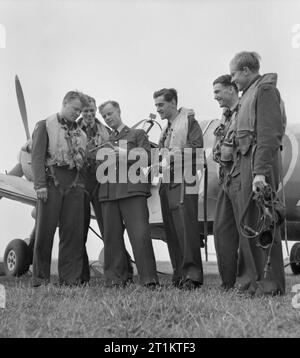 Americans in Britain- the work of No 121 (eagle) Squadron RAF, Rochford, Essex, August 1942 An intelligence officer collects information from an Eagle Squadron Spitfire crew after a flight. Left to right, they are: Flying Officer K M Osbourne, Flight Lieutenant Seldon R Edner, the intelligence officer, Squadron Leader W R Williams DFC (the Commanding Officer), Pilot Officer Don A Young and Pilot Officer F R Boyles. Stock Photo