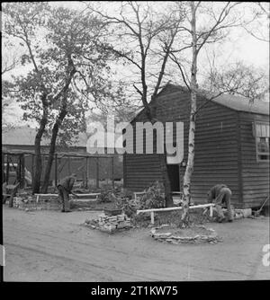 Wakefield Training Prison and Camp- Everyday Life in a British Prison, Wakefield, Yorkshire, England, 1944 In their spare time, inmates at Wakefield Training Prison tend the gardens they have created outside their huts. Stock Photo