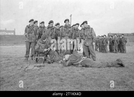 Belgian Commandos in Training in Britain, 1945 Men of the Belgian Army learn to use a Bren gun as part of their Commando training at a British Commando School. The NCO records to the second the time allowed for firing. Stock Photo