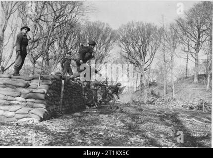 Belgian Commandos in Training, UK, 1945 Men of the 2nd battalion, 2nd Belgian Brigade jump over a wall of sandbags as part of an obstacle course completed during their Commando training, somewhere in Britain. Stock Photo