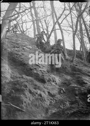 Belgian Commandos in Training, UK, 1945 Men of the 2nd Battalion, 2nd Belgian Brigade half run, half slide down a steep wooded slope as part of their Commando training, somewhere in Britain. Stock Photo