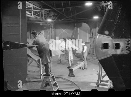 Birth of a Bomber- Aircraft Production in Britain, 1942 Men and women at work on the tail of a Halifax bomber at the Handley Page factory at Cricklewood. Stock Photo