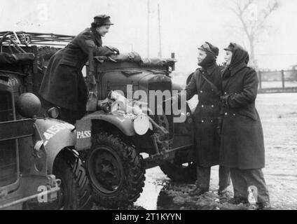 Auxiliary Territorial Service, 1941 Auxiliary Territorial Service (ATS) members in conversation beside two of the vehicles they are trained to drive, 28 January 1941. Stock Photo