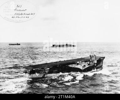 The Royal Navy escort carrier HMS Pursuer (D73) underway in March 1944HMS Furious (47) is and another escort carrier are visible in the background. Stock Photo