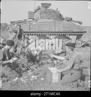 The British Army in the Normandy Campaign 1944 The crew of a Sherman tank of 1st Northamptonshire Yeomanry receive rations before the start of Operation 'Totalise', 7 August 1944. Stock Photo