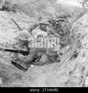 Men of 'D' Company, 1st Battalion, The Green Howards occupy a captured German communications trench during the offensive at Anzio, Italy, 22 May 1944. Men of 'D' Company, 1st Battalion The Green Howards, 5th Infantry Division, occupy a captured German communications trench during the offensive at Anzio, 22 May 1944. Stock Photo