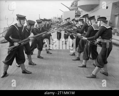 The Royal Navy during the Second World War Rifle drill; sailors facing each other whilst standing in the 'on guard' position during practice on board HMS RODNEY. Stock Photo