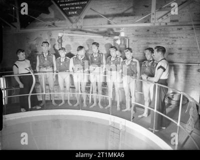 The Royal Navy during the Second World War Davis apparatus brings submarine-trapped men to safety at HMS DOLPHIN, Gosport. Here a class of trainees wear their apparatus as they listen to instructions on its use before the practical demonstration inside the giant tank. Stock Photo