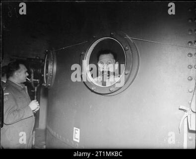 The Royal Navy during the Second World War Davis apparatus brings submarine-trapped men to safety at HMS DOLPHIN, Gosport. Here is an under-water view of an instructor equipped with Davis apparatus looking through a glass scuttle in the walls of the tank. Stock Photo