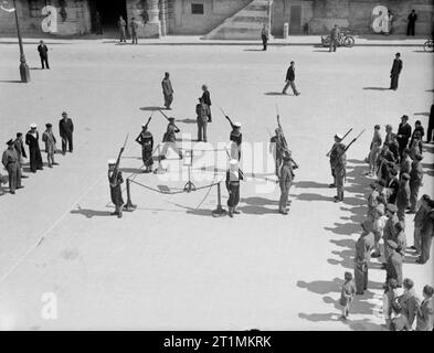 The Royal Navy during the Second World War Maltese ratings changing guard with the King's Own Malta Regiment in Palace Square as the George Cross is ceremoniously displayed in Palace Square, Valletta on the first anniversary of Malta being awarded the George Cross by His Majesty King George VI on 15 April 1942. Stock Photo