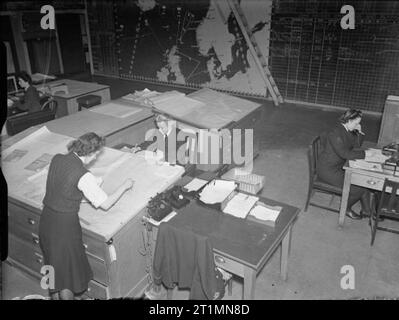 The Royal Navy during the Second World War Wrens at work in the plotting room in a naval operational centre at Rosyth. Deep underground they plot the position of Allied and enemy ships on large scale charts. A thousand or more secret messages pass daily through the Wrens' hands. Stock Photo