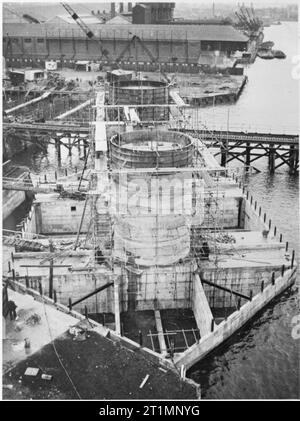 The Royal Navy during the Second World War Maunsell Sea forts in the Thames Estuary: In the dock basin the twin towers of a sea fort to be used in the Thames Estuary are rapidly rising from the floating pontoon. A pre-assembled spot welded cage is hoisted into position, and the concrete is poured between a permanent wooden inner wall and an outer steel shell. Then the steel shell is moved up and the next cast is made. These secret forts were an effective defence against attacks by sea and air on the estuary. Stock Photo