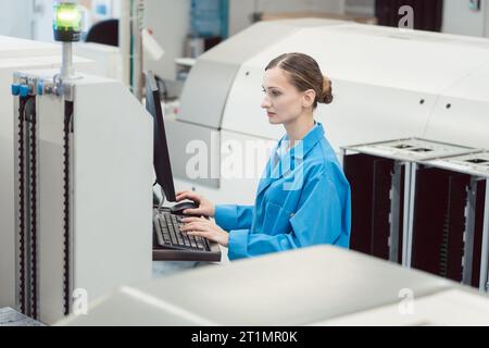 Manufacturing worker checking data of assembly line on screen Stock Photo