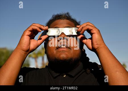 Las Vegas, Nevada, USA. 14th Oct, 2023. A man looks at the sun with solar glasses during an annular solar eclipse on October 14, 2023 in Las Vegas, Nevada. Differing from a total solar eclipse, the moon in an annular eclipse appears too small to cover the sun completely, leaving a ring of fire effect around the moon. The next annular solar eclipse visible from the United States won't happen until June 21, 2039. (Credit Image: © David Becker/ZUMA Press Wire) EDITORIAL USAGE ONLY! Not for Commercial USAGE! Stock Photo