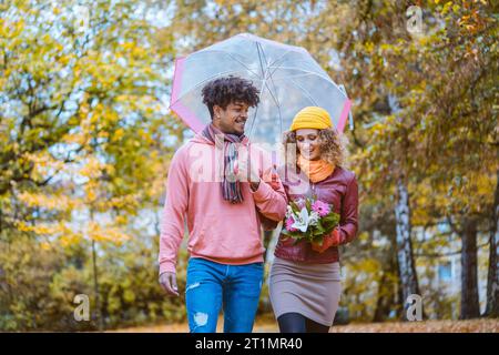Couple with different ethnicities having a autumn walk in the park Stock Photo