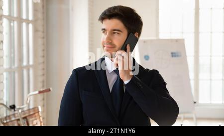 Happy pensive business owner man talking on cell Stock Photo