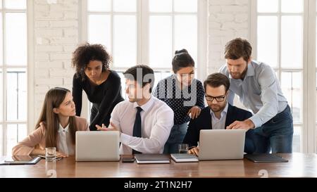 Two diverse group of colleagues meeting at laptops, using computers Stock Photo