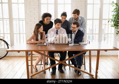 Diverse managers meeting at table with laptop, using modern technology Stock Photo