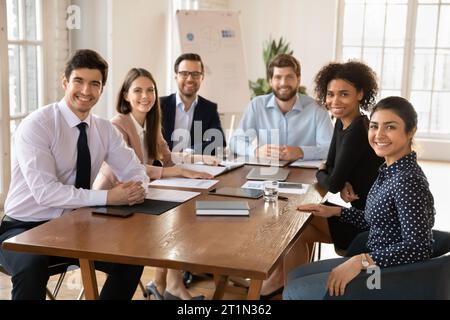Happy young diverse team of professionals posing at office table Stock Photo
