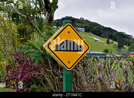 Yellow street traffic warning sign indicating speed bump Stock Photo