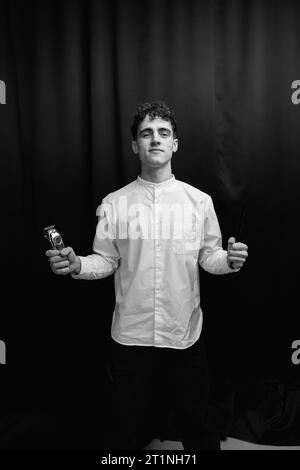 Barber holds in his hands a clipper and a comb Stock Photo