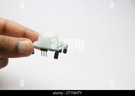 Passive infrared or in short PIR sensor module for motion detection used in robotics projects held in the hand Stock Photo