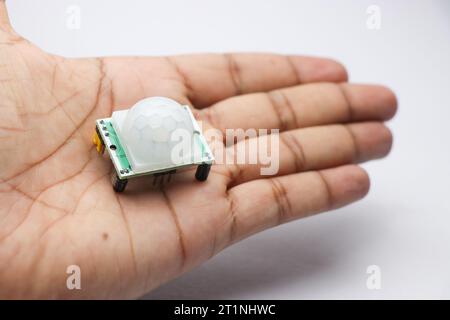 PIR sensor module for motion detection in robotics projects held in the hand. Useful electronic components to make electronic projects Stock Photo