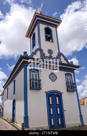 View to small beautiful chapel in white and blue against blue sky with white clouds in historic town Diamantina, Minas Gerais, Brazil Stock Photo