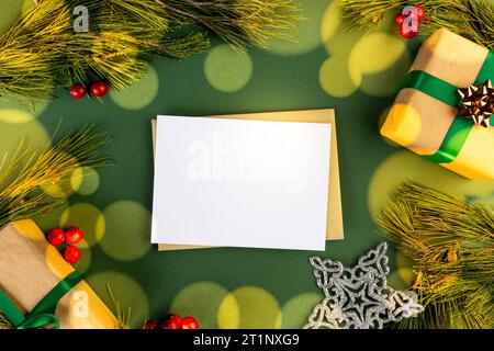 Christmas decorations and white card with copy space on green background Stock Photo