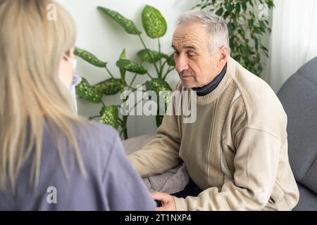 Portrait of mature female psychiatrist interviewing handicapped senior man during therapy session, copy space. Stock Photo