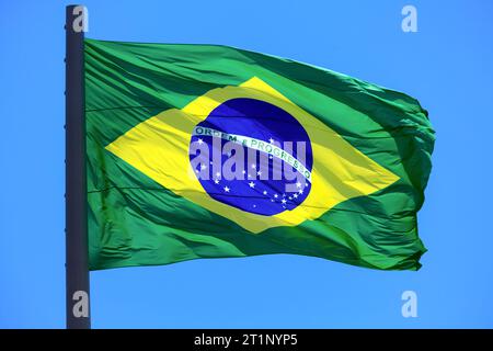 Brazilian flag waving in the wind on blue sky background. Flag of Brazil. Stock Photo