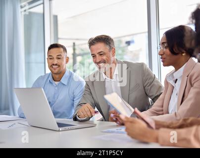 Happy diverse business employees team working at group meeting using laptop. Stock Photo