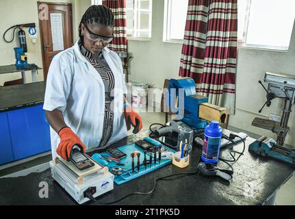 Female technician at the Vocational training centre repairing a mobile phone in Dar es Salaam, Tanzania on October 1, 2021 Stock Photo