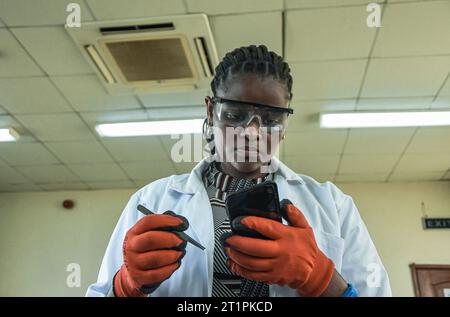 Female technician at the Vocational training centre repairing a mobile phone in Dar es Salaam, Tanzania on October 1, 2021 Stock Photo