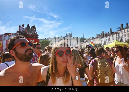 PRIDE March and celebrations in Place Bellecour, Lyon, France. A woman in red heart shaped sunglasses and a man in red wayfarers at a Stock Photo
