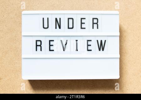 Lightbox with word under review on wood background Stock Photo