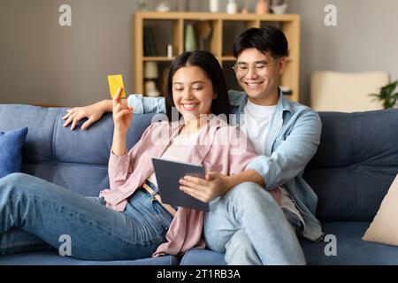 Asian couple customers using tablet pc for online shopping indoor Stock Photo