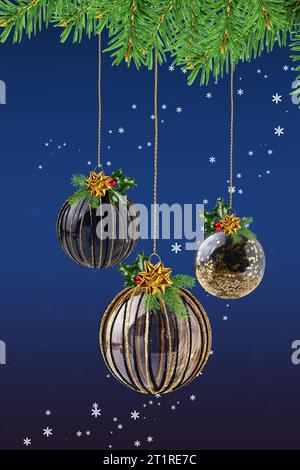 Christmas ornaments hanging on Christmas tree branches over blue background. Christmas and New Year greeting card. Stock Photo