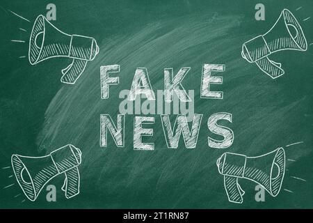 Megaphones with the text FAKE NEWS drawn in chalk on a greenboard. Hand drawn illustration. Information and disinformation concept. Stock Photo